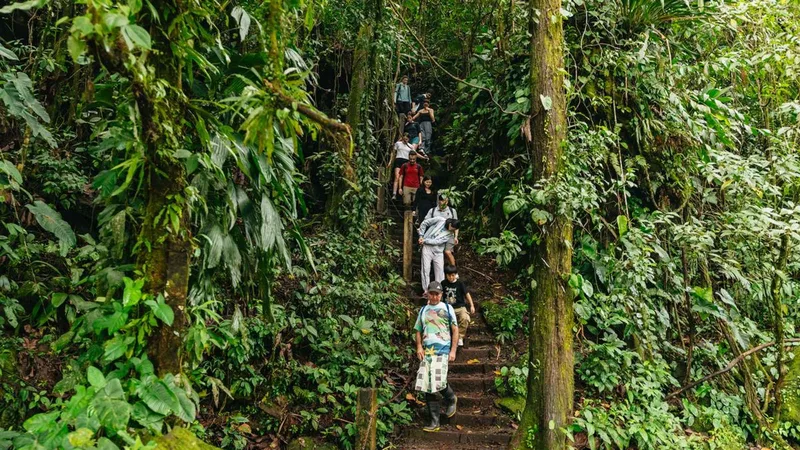 Hikers relaxing at a natural hot springs resort pool after a La Fortuna waterfall and Arenal Volcano hot springs tour near La Fortuna, Costa Rica